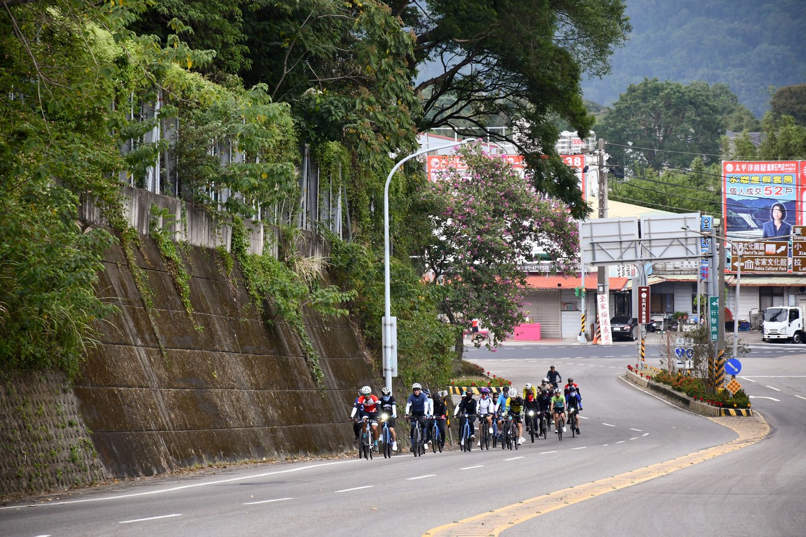 The group riding through a small town with hills rising behind