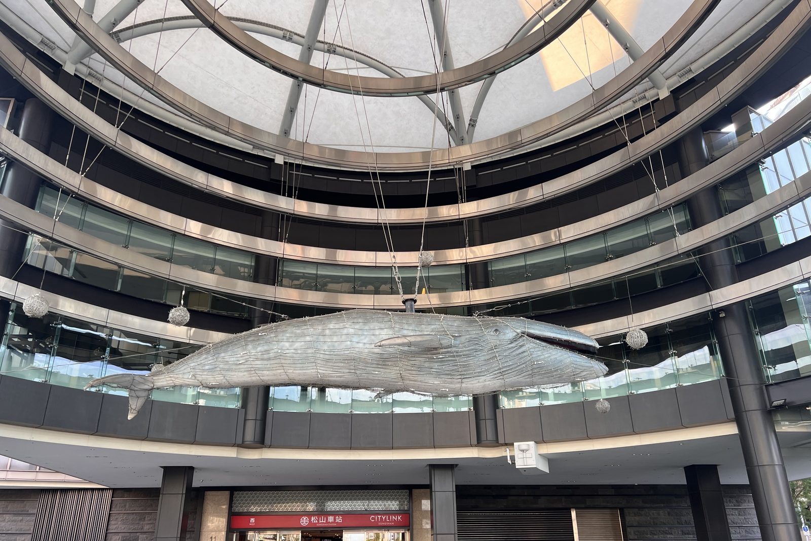 A giant woven whale sculpture hanging inside Songshan Station
