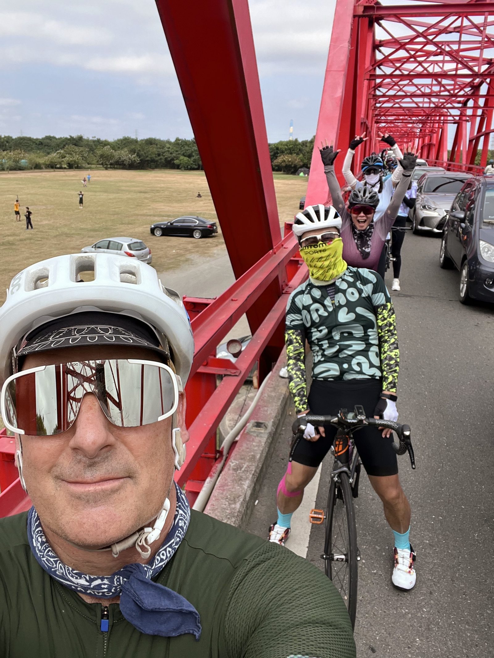 The group cheering atop a red truss bridge