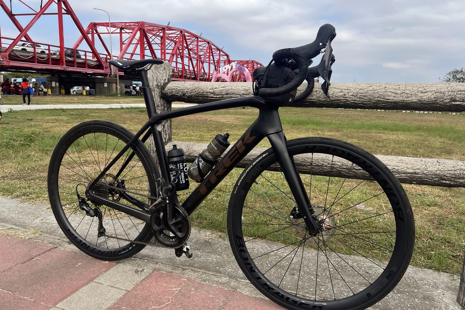 The bike resting against a rail by the bridge