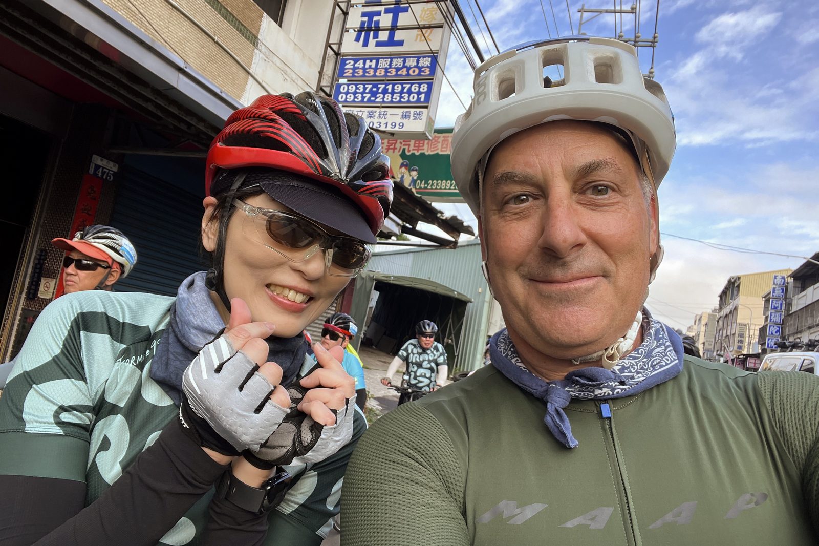 A street-side selfie past a row of shops