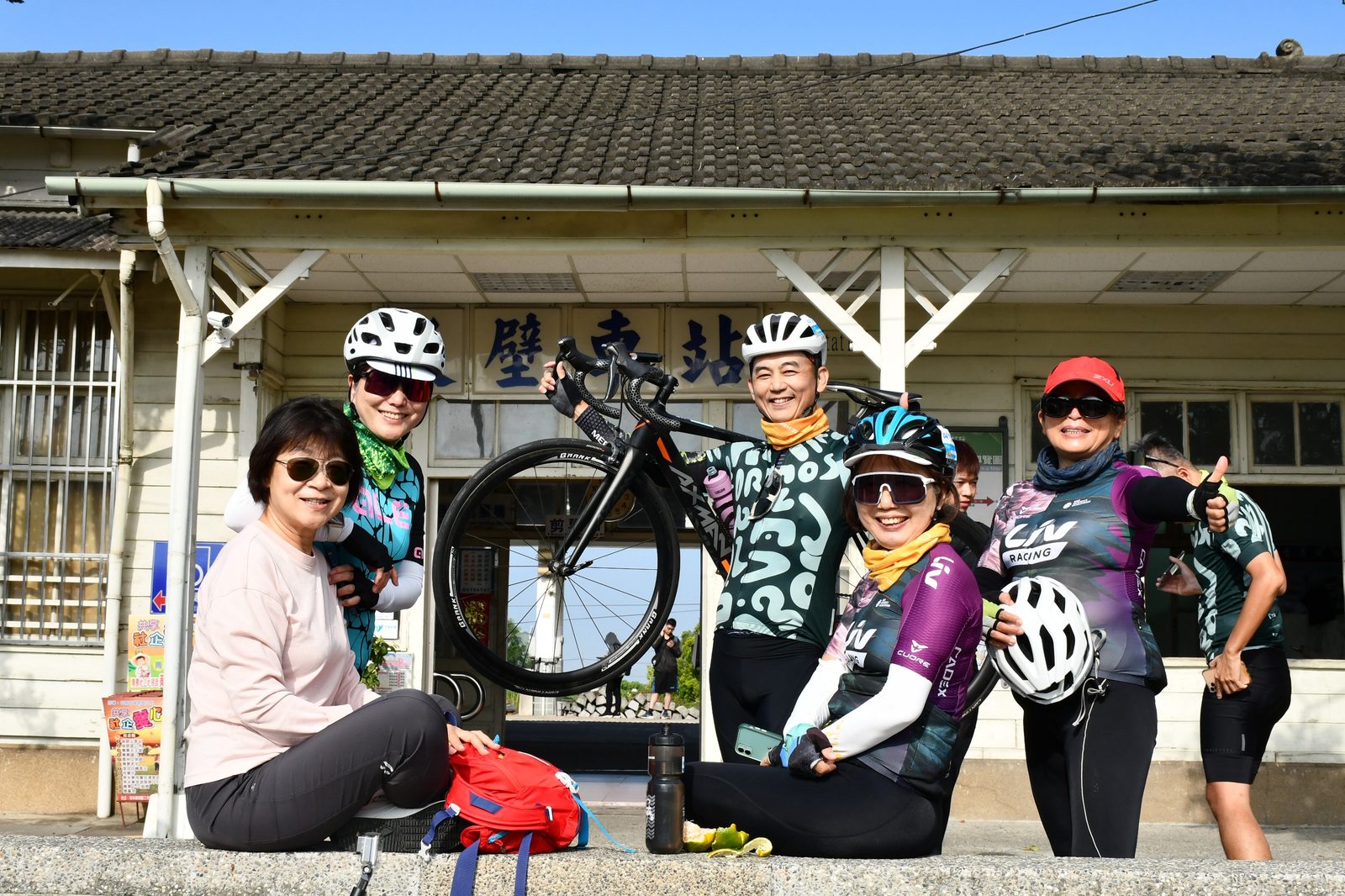 Friends gathered with a bike held high at Houbi Station