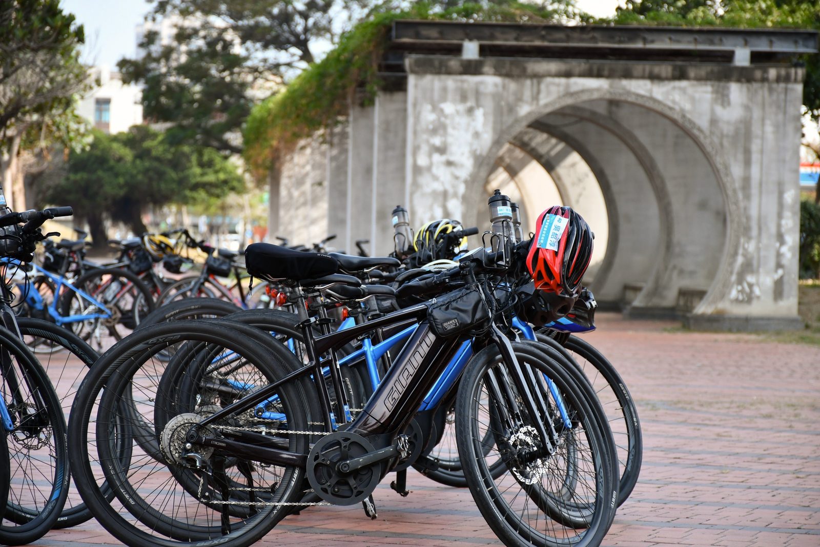 Bikes and helmets resting by an old stone tunnel