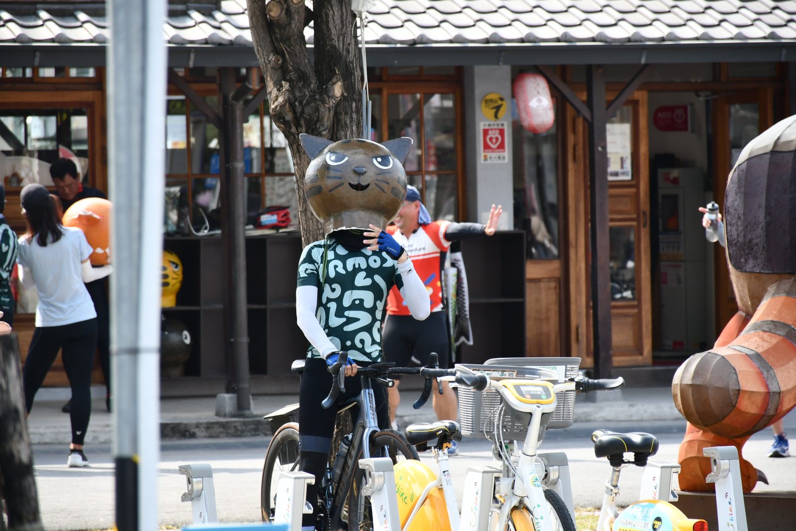 A peace sign beside a cat-headed mascot statue