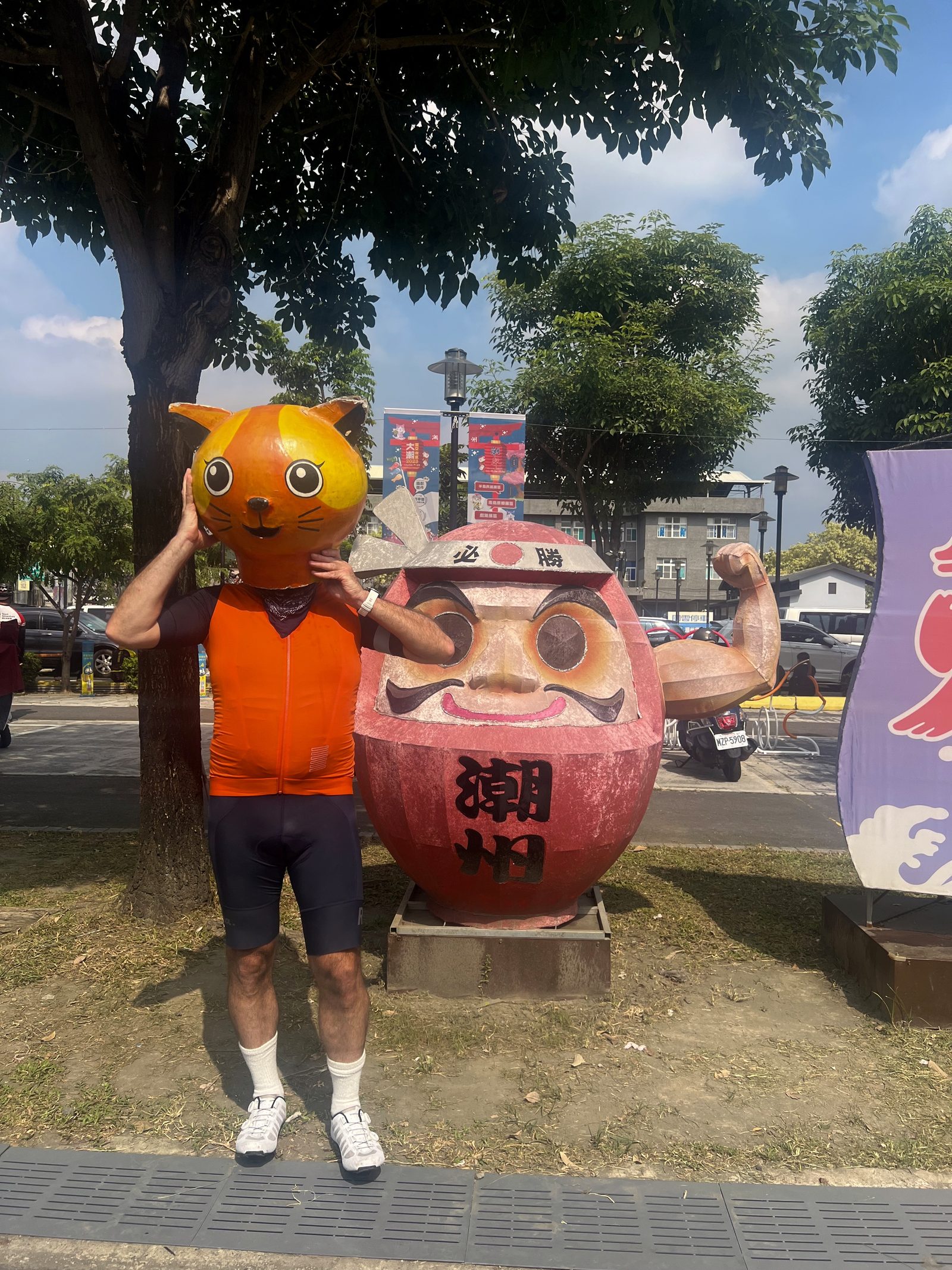 Flexing alongside the daruma statue