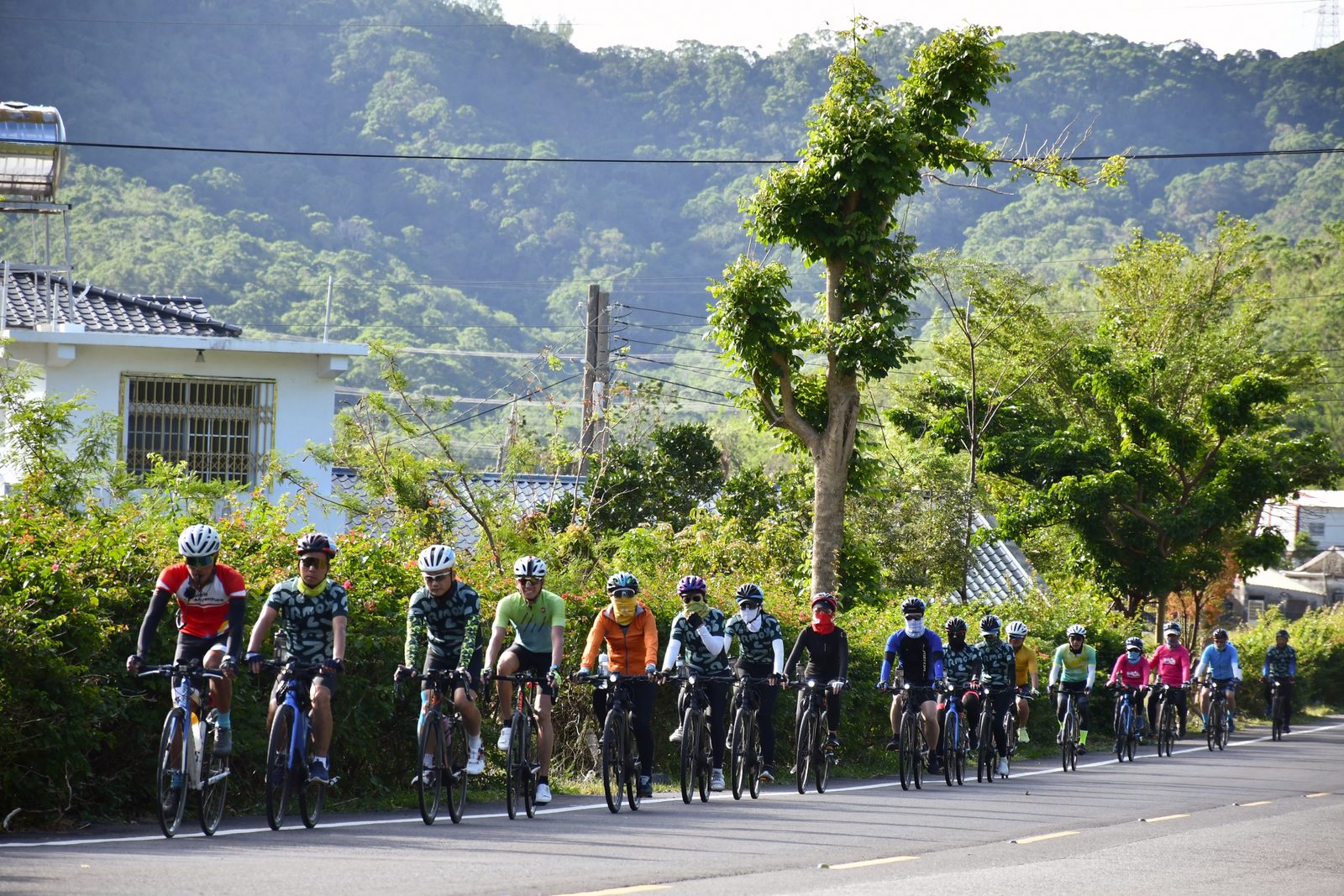 The full group riding together past the village houses