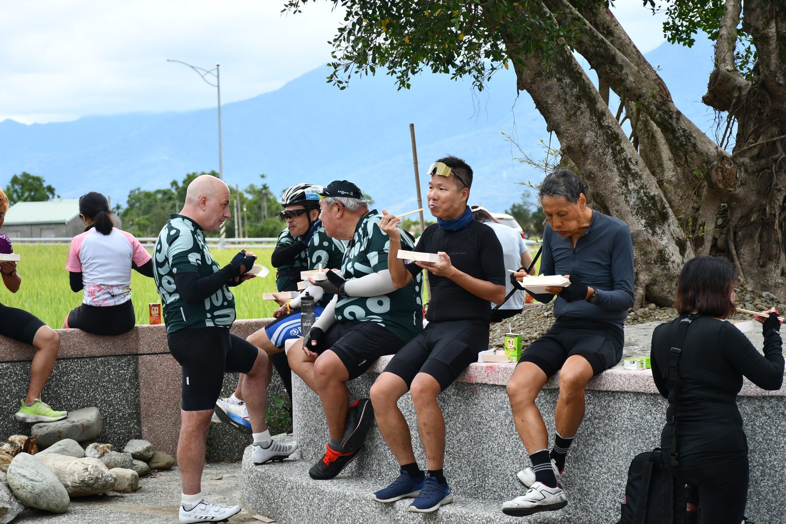 Lunch break on a stone wall above the rice fields