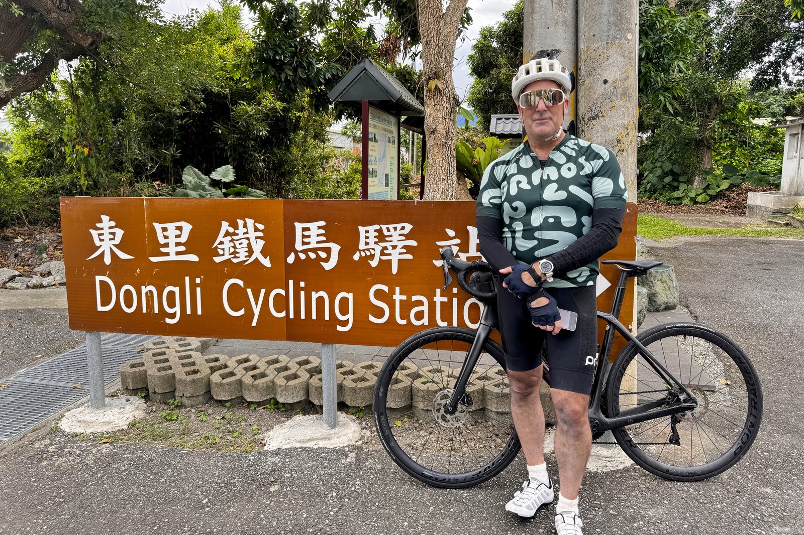 Posing at the Dongli Cycling Station sign