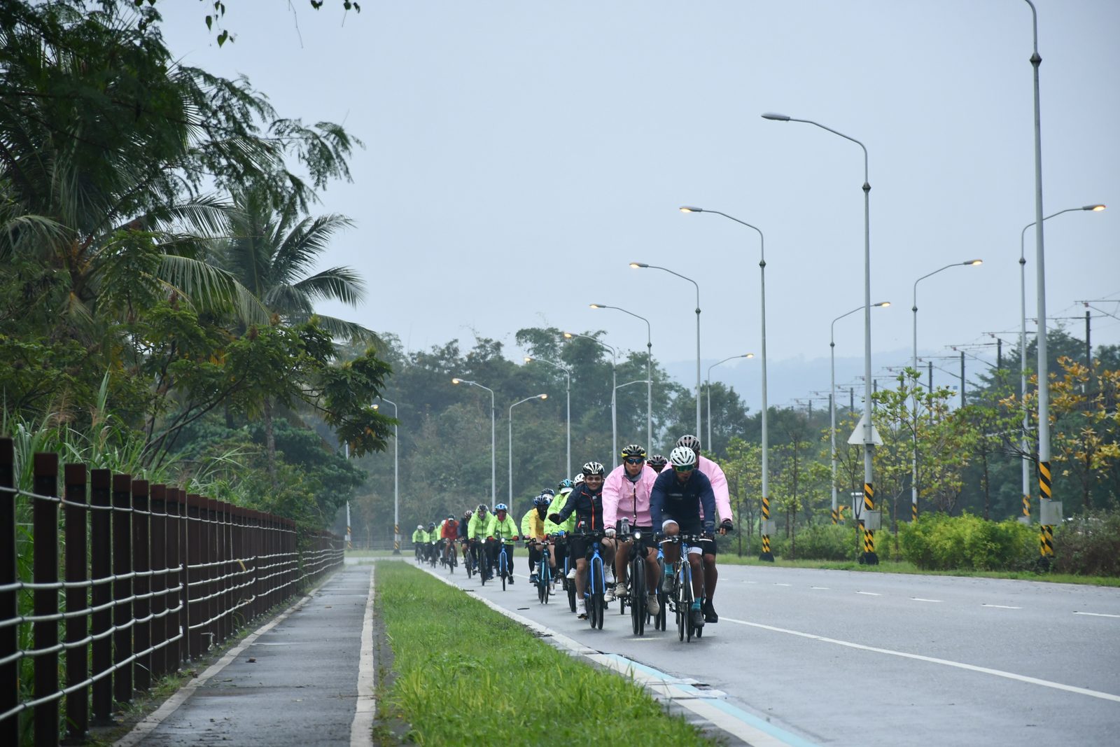 Riders in rain jackets heading down the road