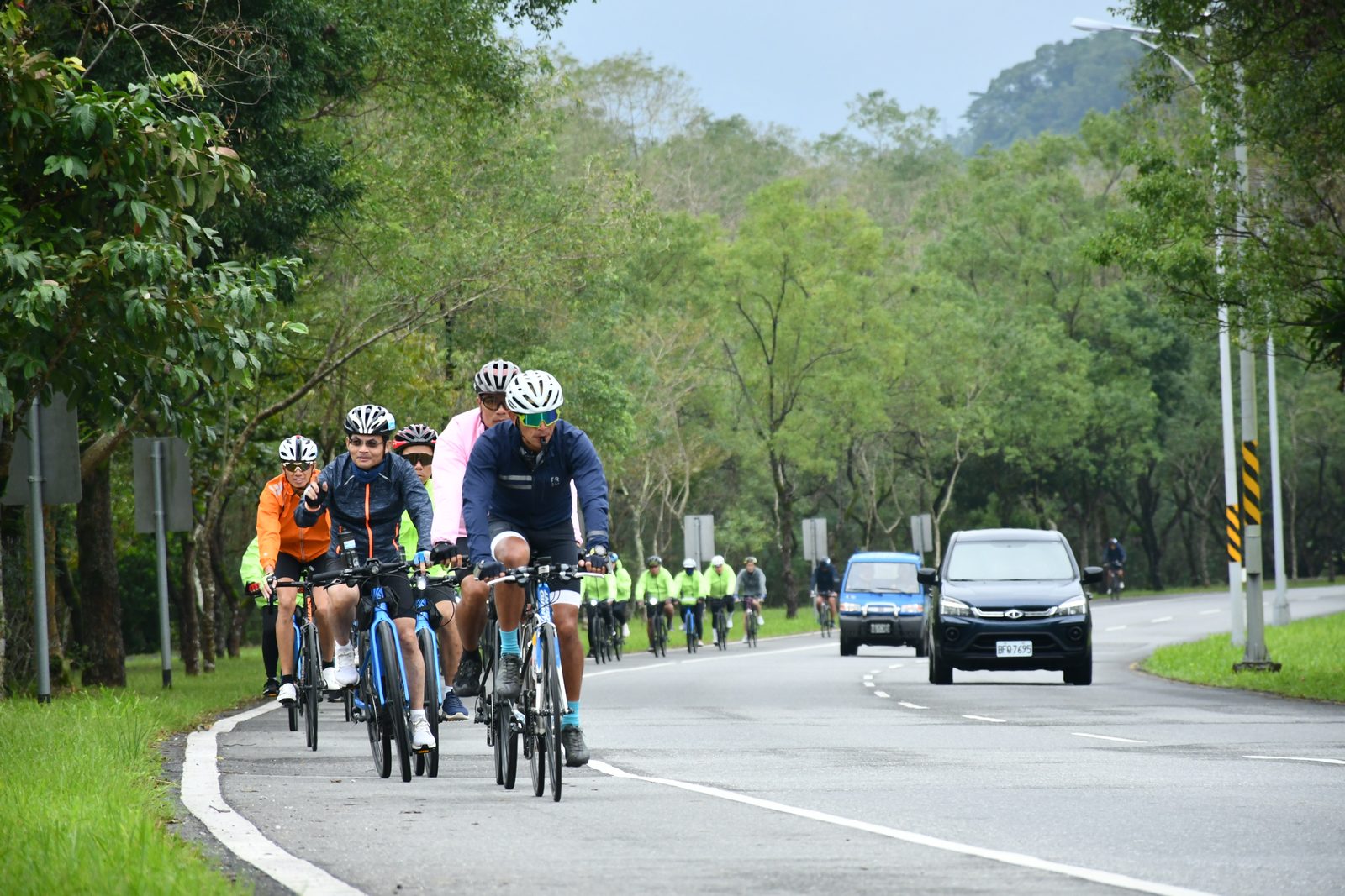 Riders approaching through the rain and traffic