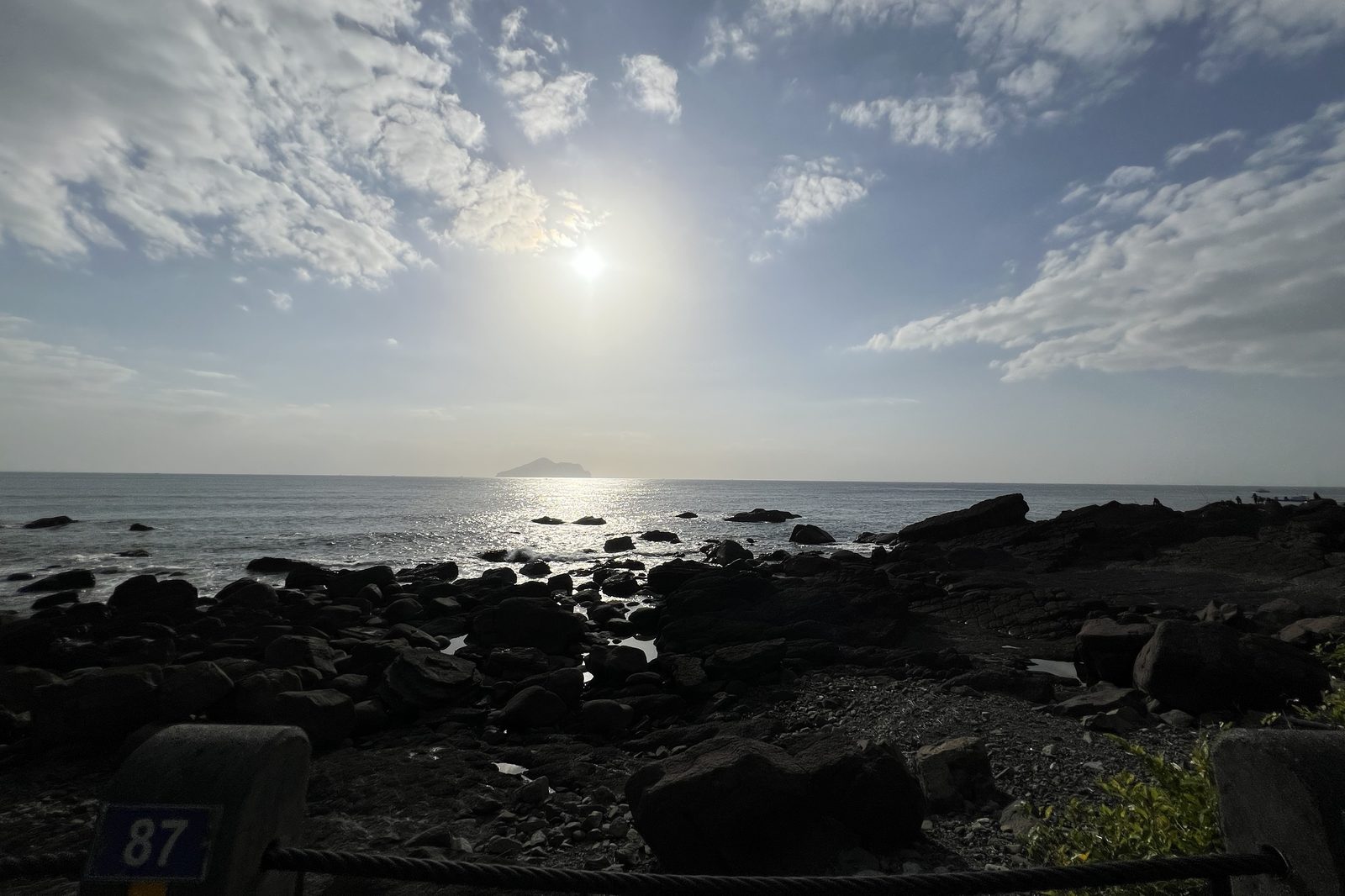 Turtle Island silhouetted against a glittering sea