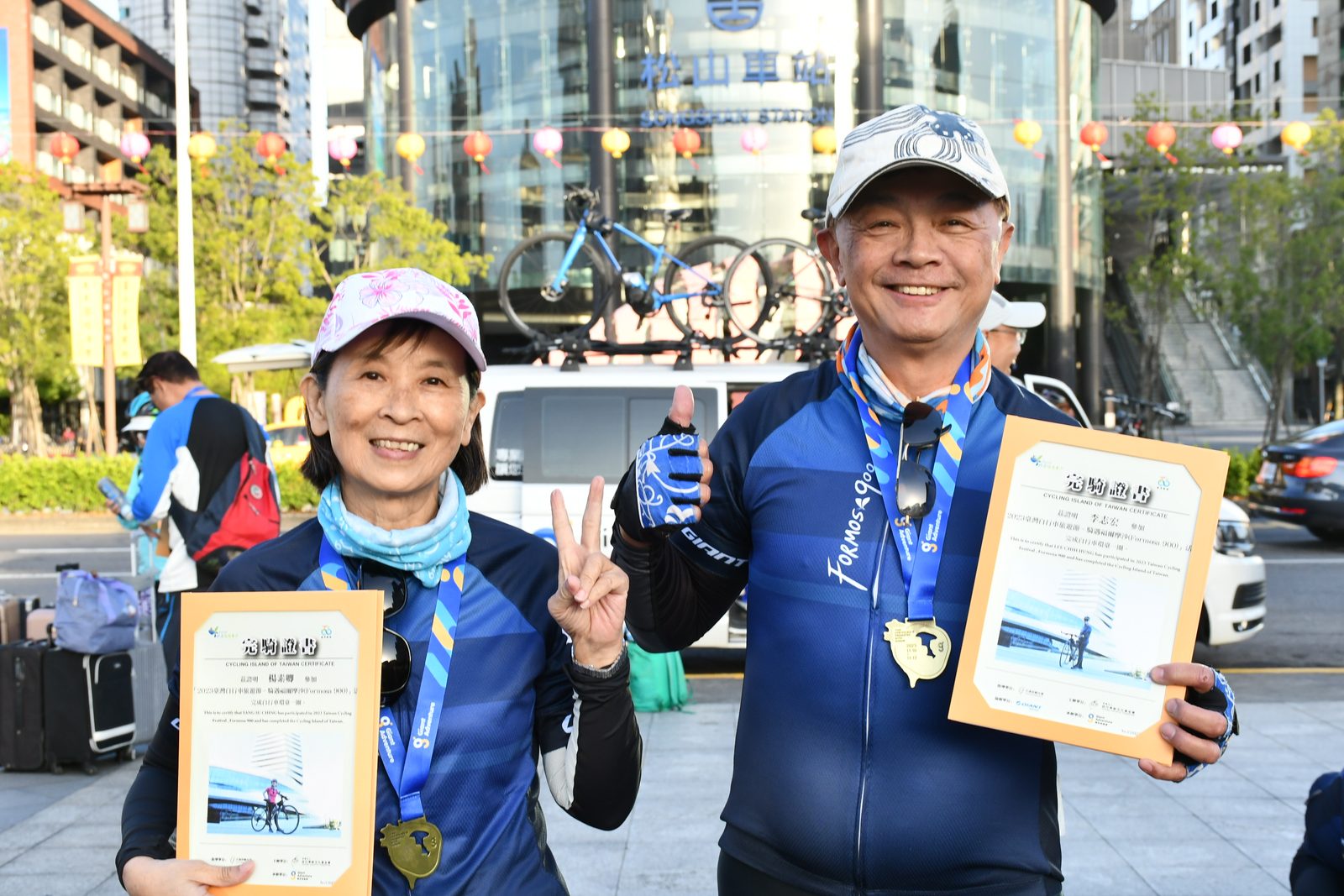 A couple celebrating with their finisher certificates